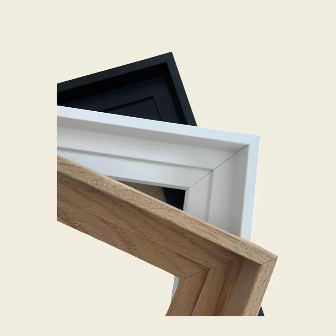 Gros plan sur trois angles de cadres Scarlett superposés, en noir, blanc et bois brut