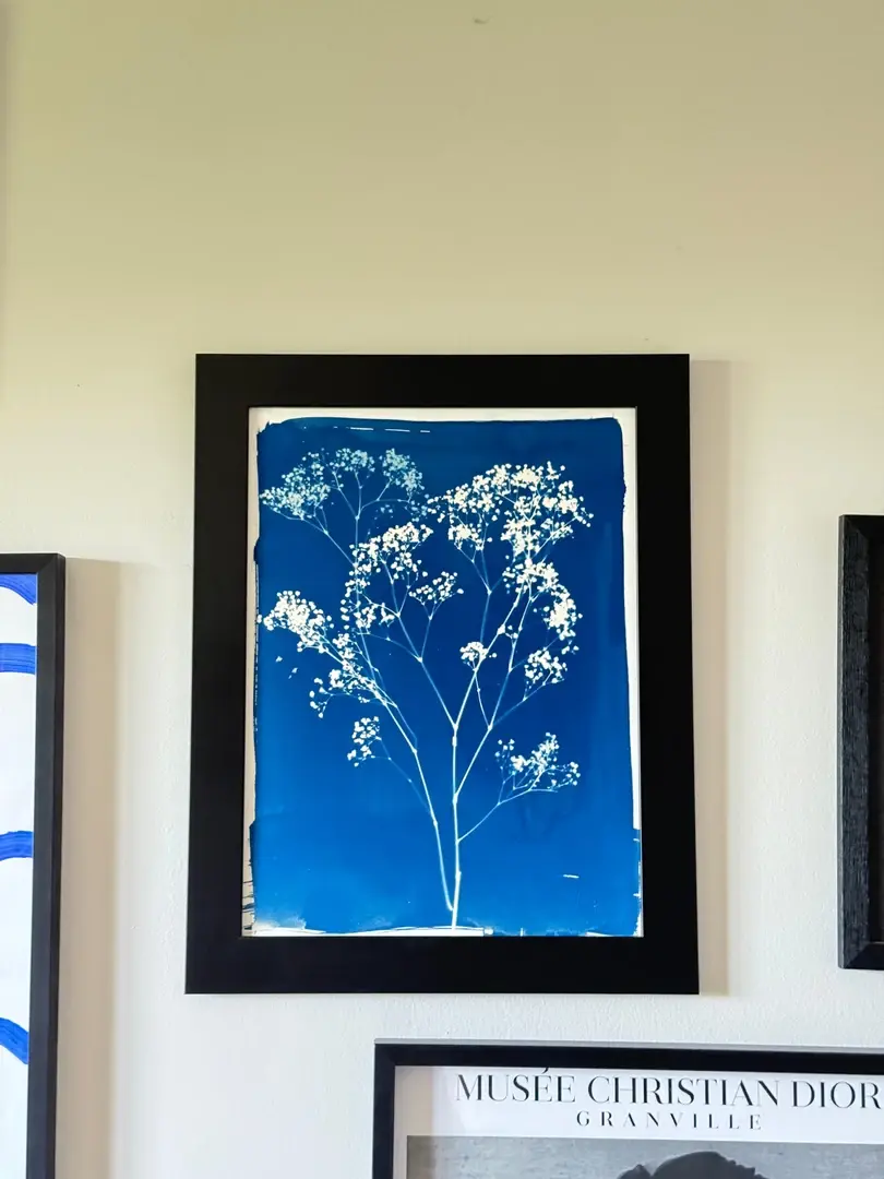 Cadre Romy noir à profil large au mur, cyanotype bleu, entouré d'autres cadres
