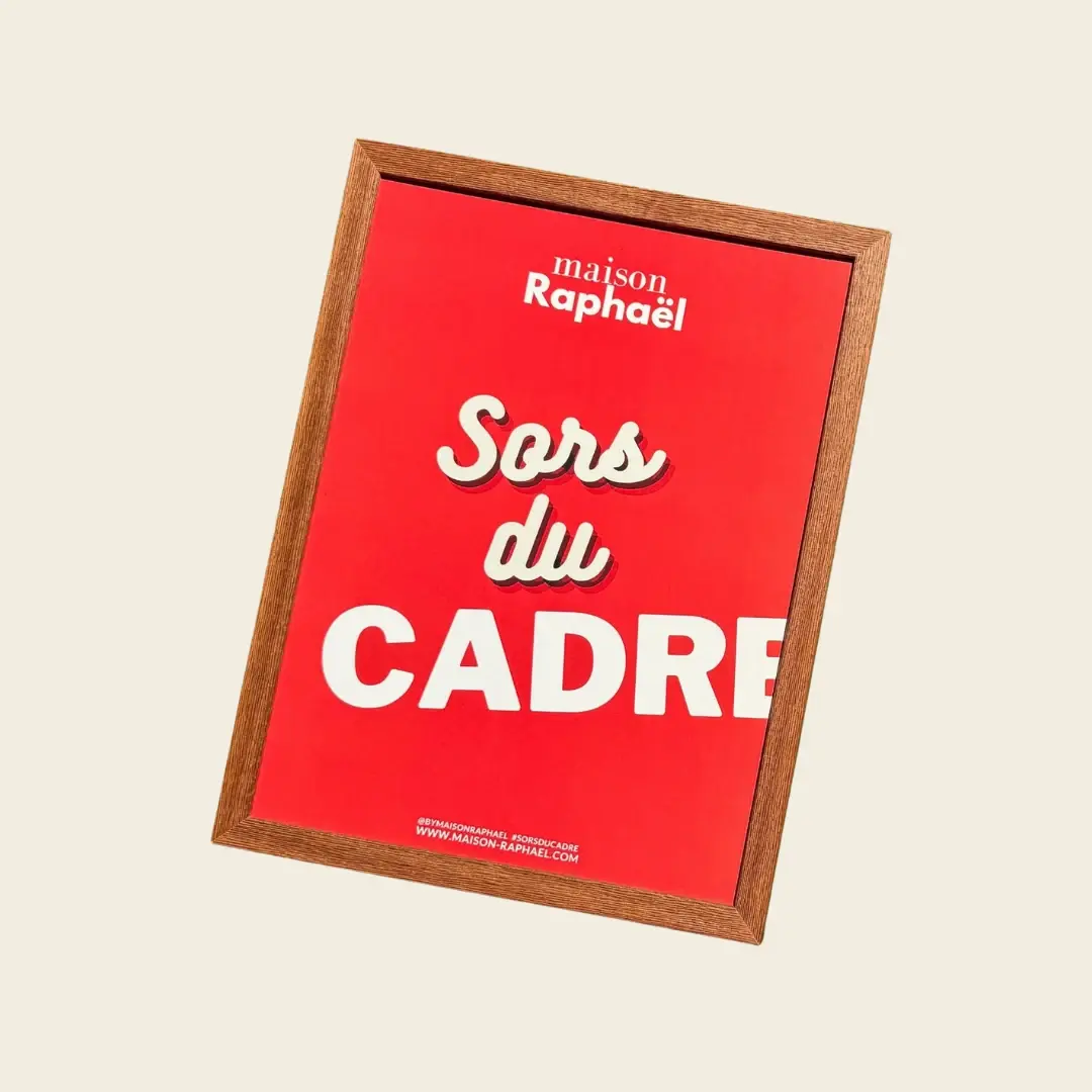 Cadre Gabrielle en Wengé, présenté incliné avec une affiche rouge