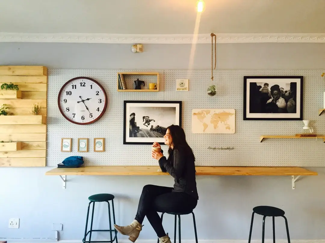 Café avec comptoir, panneau perforé et photos noir et blanc encadrées au mur