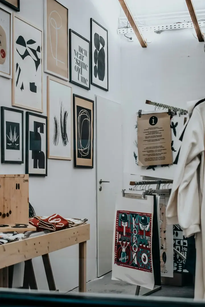 Boutique de vêtements avec un mur d'affiches graphiques en cadres bois et noirs