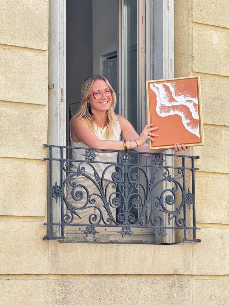 Moodea tenant à son balcon un de ses tableaux avec l'une de nos caisses americaines